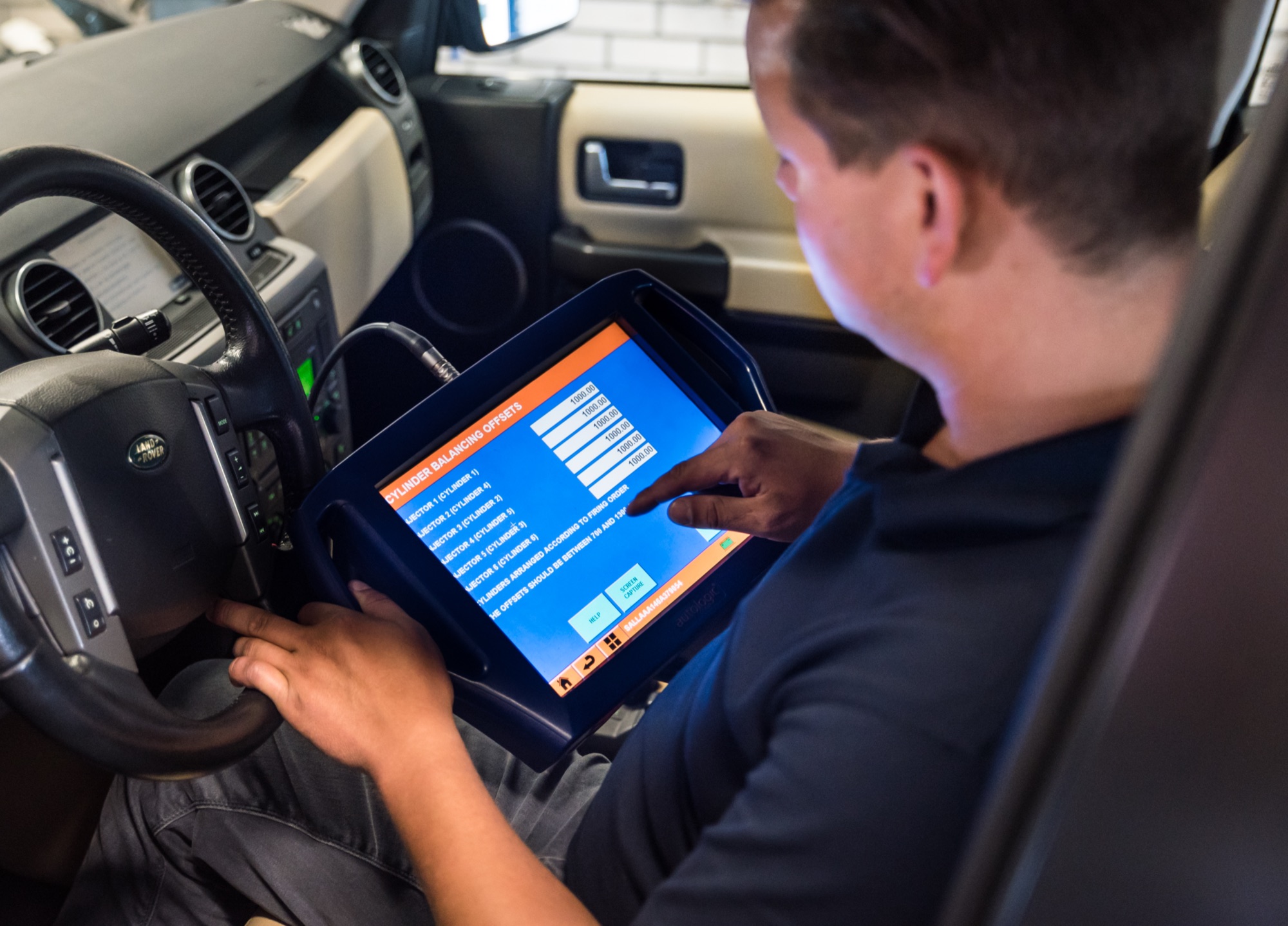 Monteur leest een Land Rover Discovery uit met een diagnosetablet