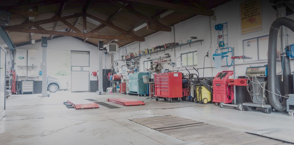 De werkplaats van Autobedrijf J. van Dreven met brugliften en gereedschapswagens