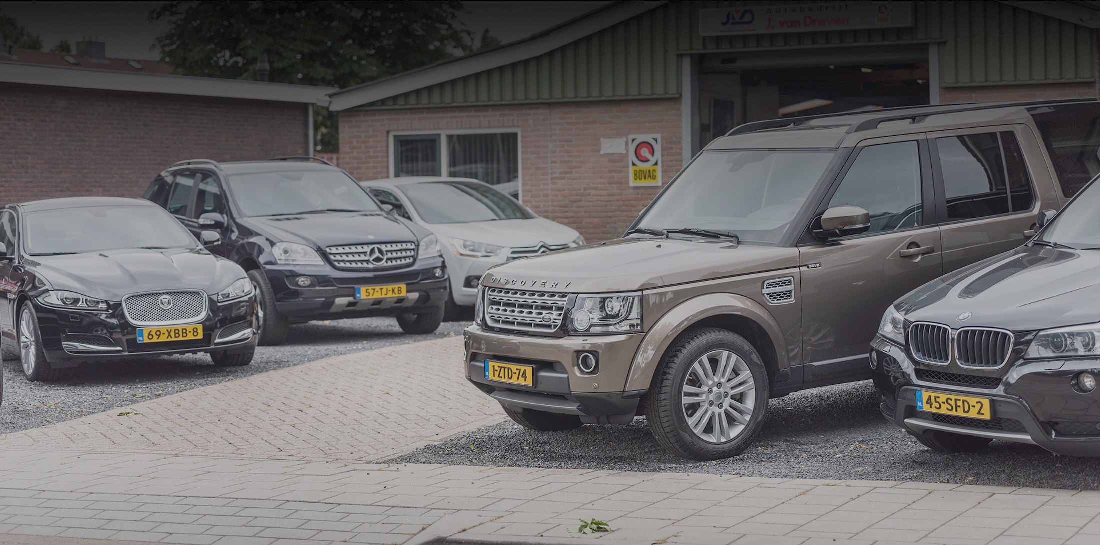 Een Jaguar, een Land Rover Discovery en een BMW voor het pand